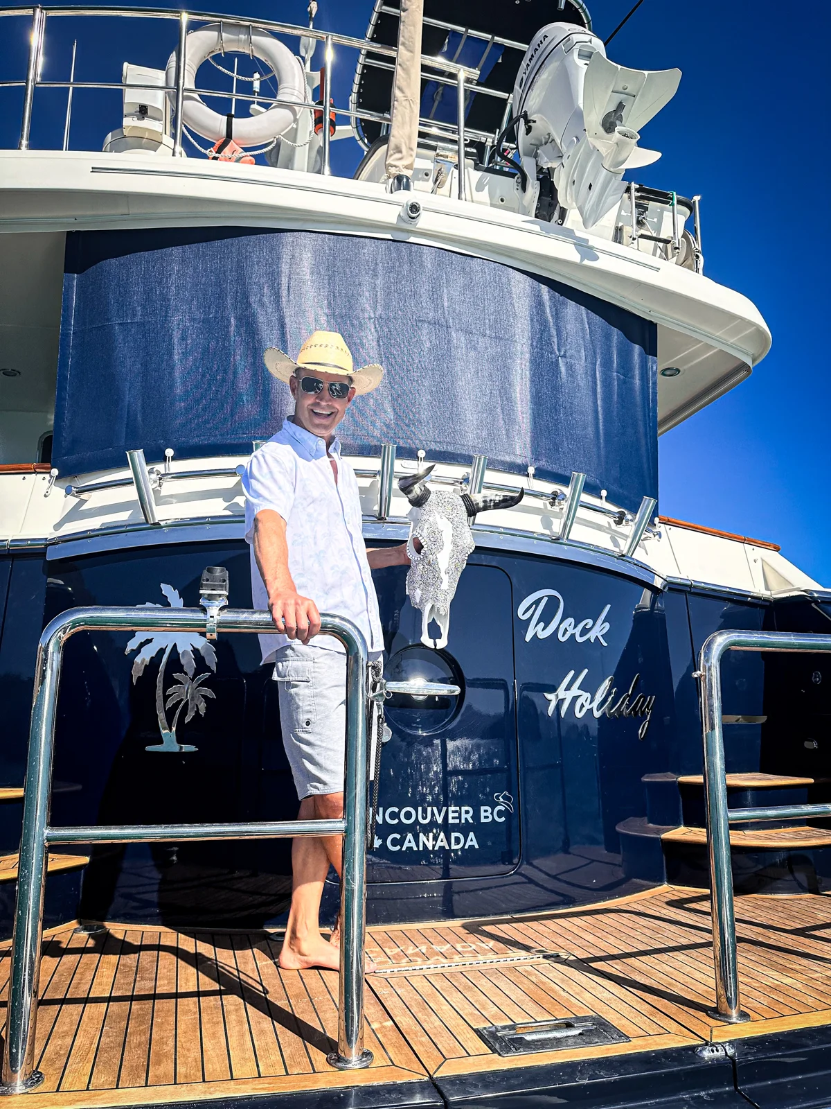 A smiling client holding a white Cabokero artwork on board a boat