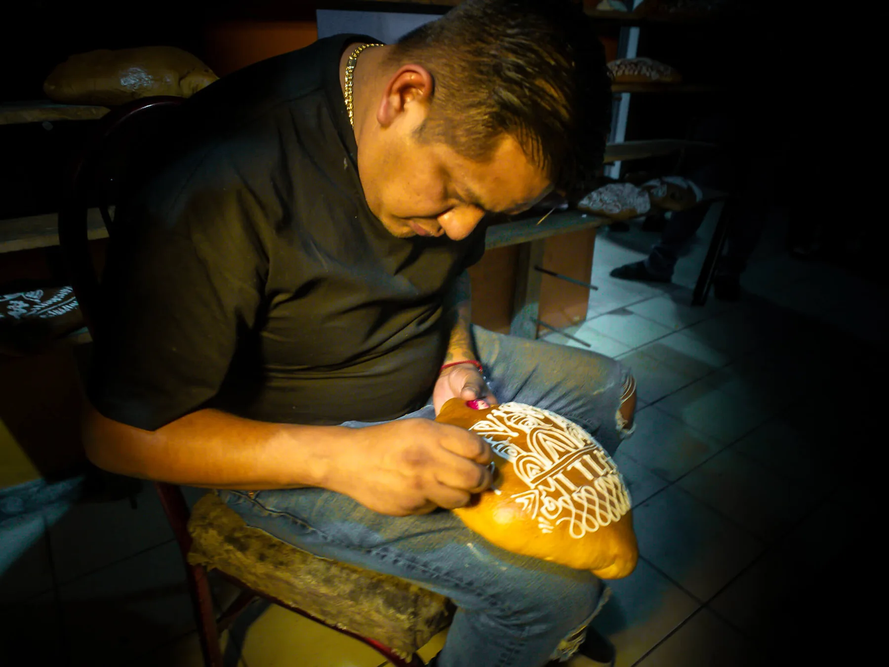 Ricardo working on the detailed decoration of a loaf of pan de muerto