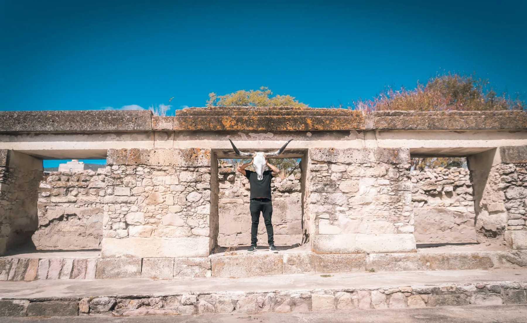 Ricardo Quero standing within the ancient stone architecture of Mitla, Oaxaca